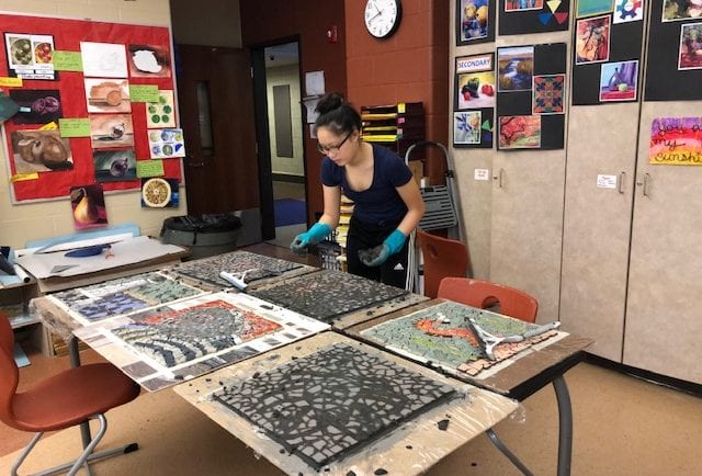 Addie moving on to grout the next mosaic
