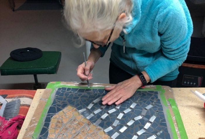 Mary putting the finishing touches on a jellyfish mosaic.